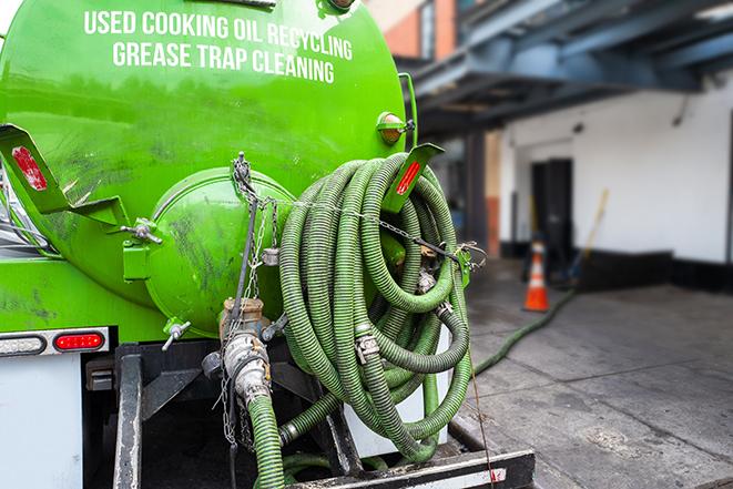 a technician pumping a grease trap in a commercial building in Akron, NY